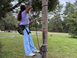 Girl aiming arrow at target