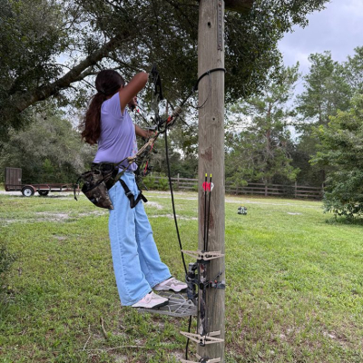Girl aiming arrow at target